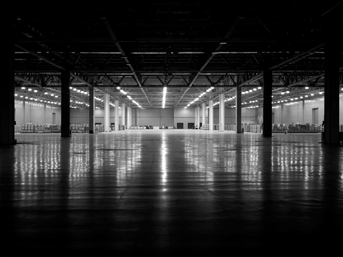 Large lit hall with a steel structure, in black and white